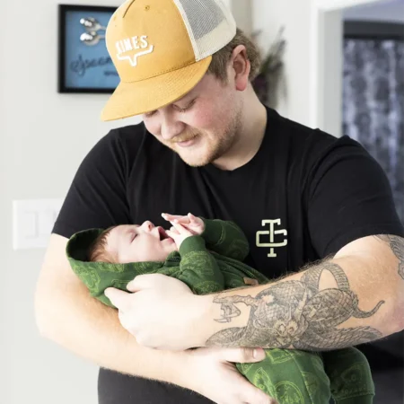 A father gently holding his newborn baby in his arms during a natural light Lifestyle Setting with Winnipeg Newborn Photographer Jason Lee A father gently holding his newborn baby in his arms during a natural light Lifestyle Setting with Winnipeg Newborn Photographer Jason Lee