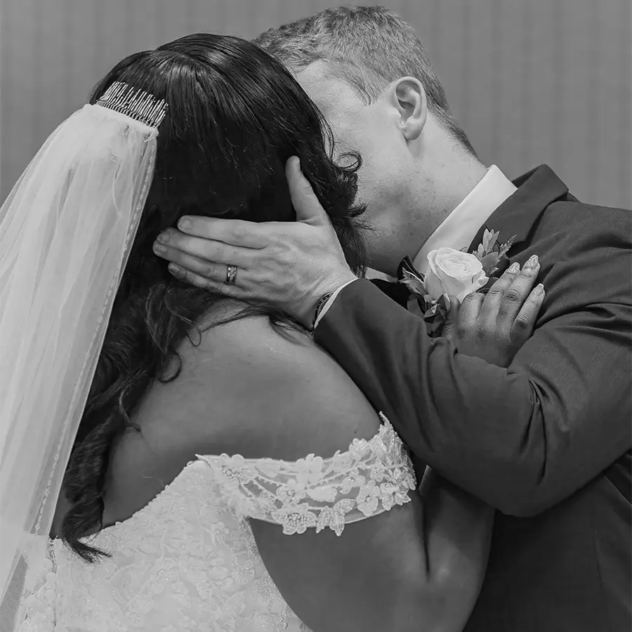 A timeless black and white photo of a bride and groom’s first kiss during their Winnipeg wedding ceremony.