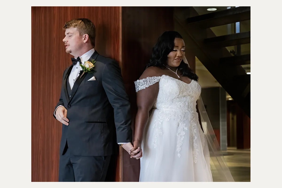 Bride and groom holding hands during a first-touch moment on their wedding day
