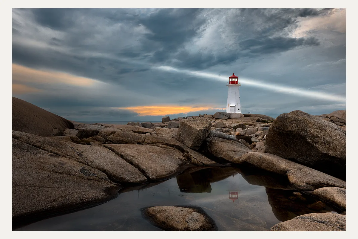 Peggy's Cove Lighthouse beneath dramatic clouds in Nova Scotia