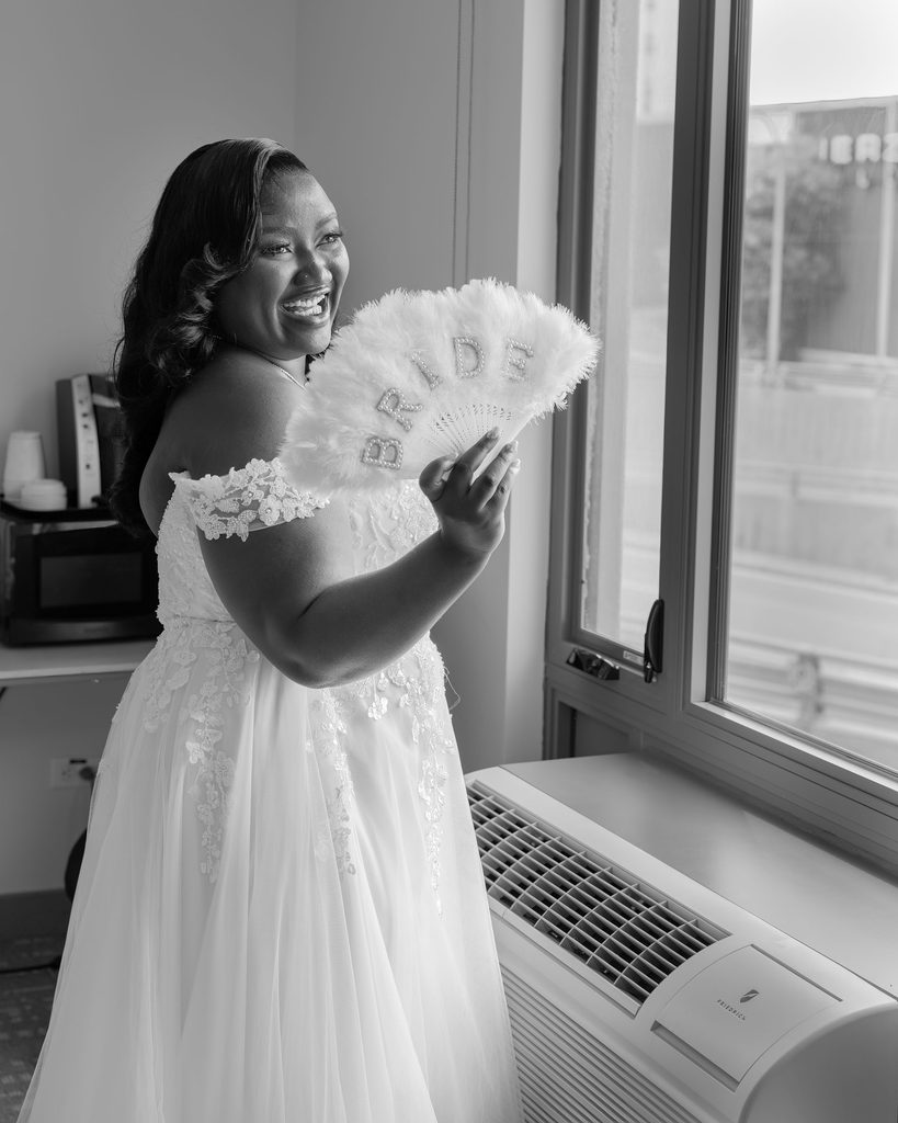 Bride laughing with a BRIDE fan while getting ready at the Viscount Gort Hotel