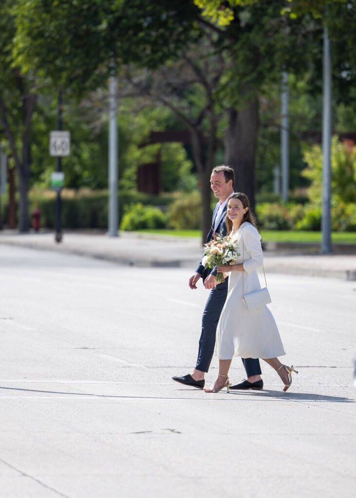 Bride and groom crossing a downtown Winnipeg street on the way to The Forks