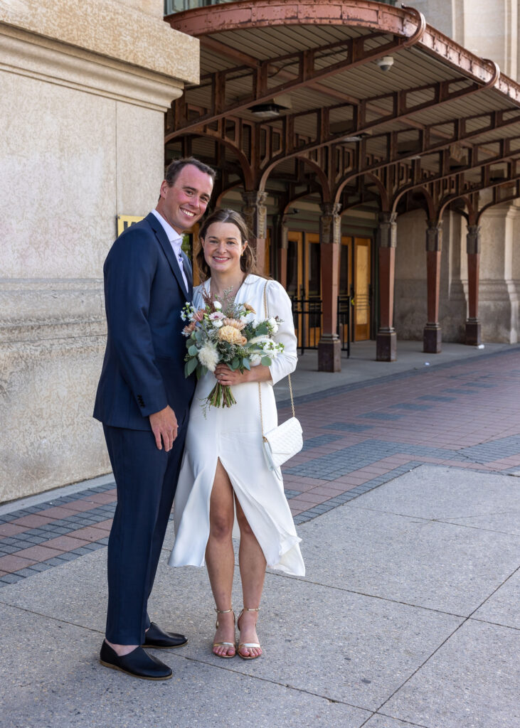 Bride and groom in front of downtown Winnipeg's historic train station on the way to The Forks