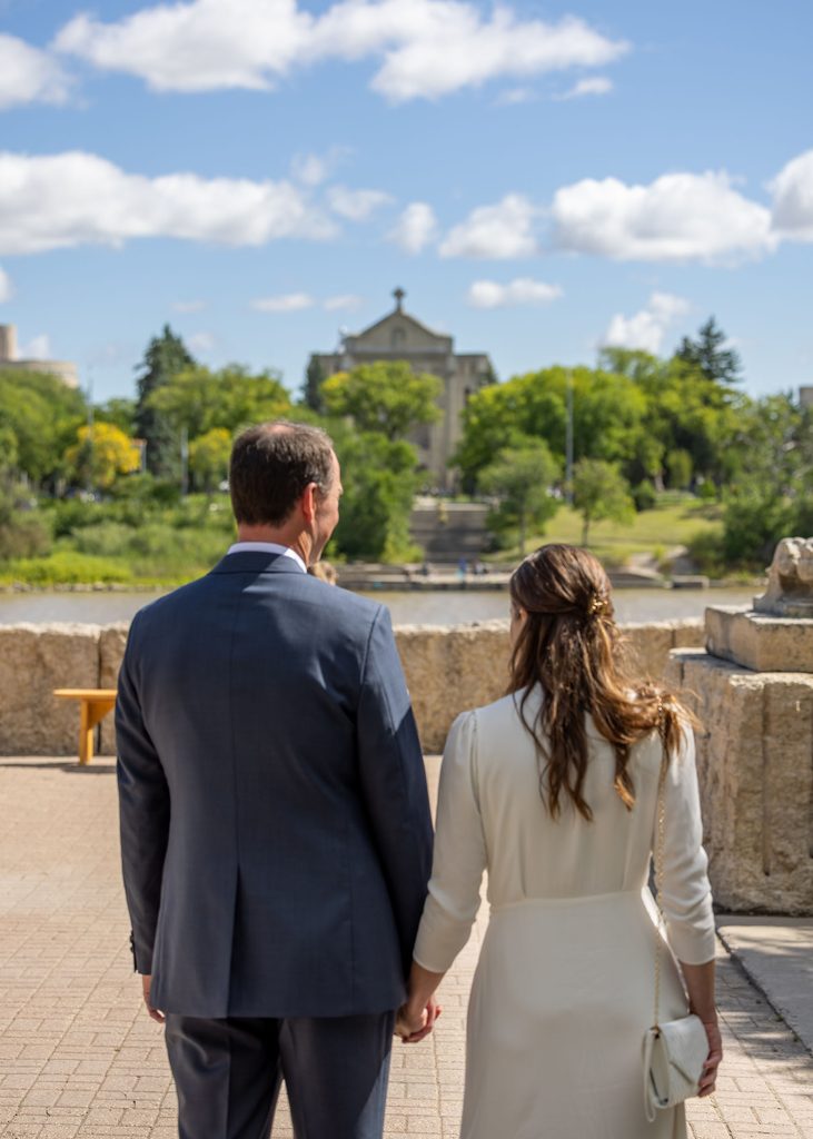 Couple overlooking the Red River toward St. Boniface Cathedral before their wedding ceremony