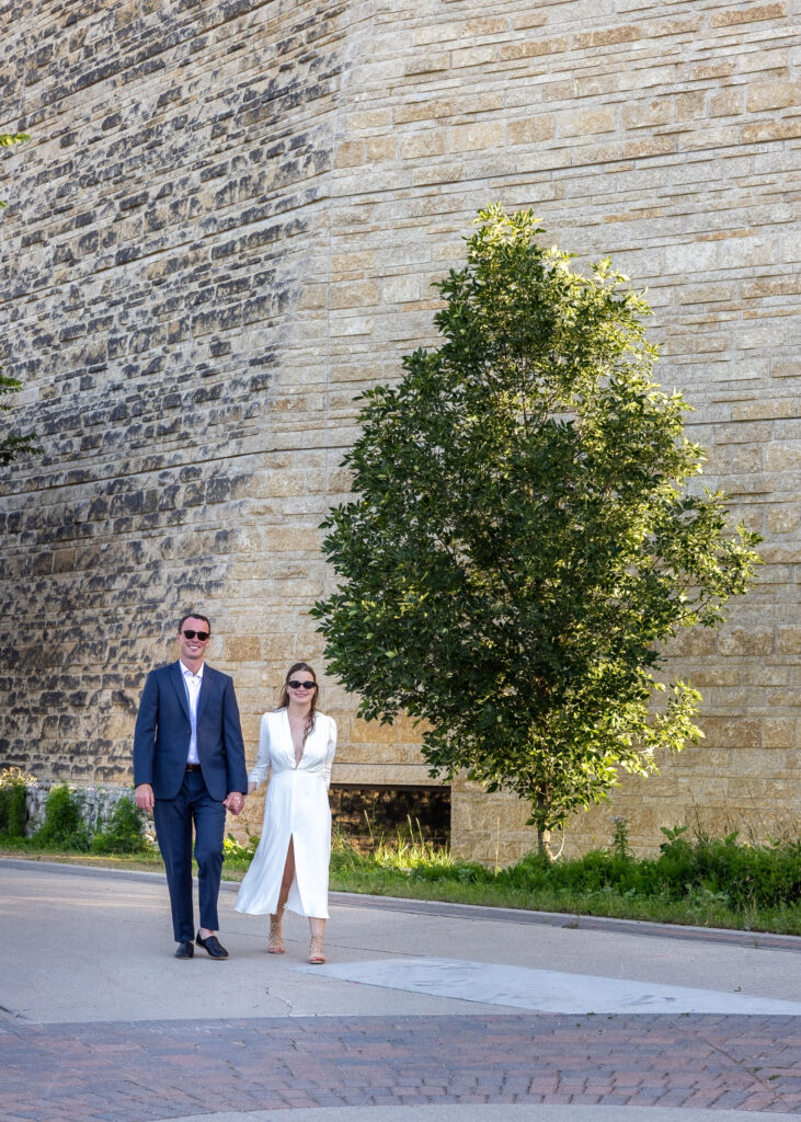 Couple walking together near The Forks in Winnipeg with the Canadian Museum for Human Rights in the background
