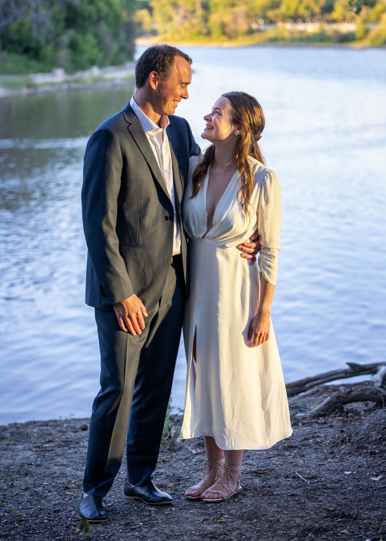 Newlyweds sharing a golden-hour portrait beside the Red River in Winnipeg