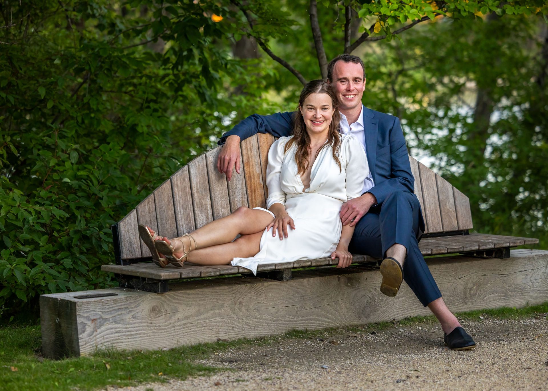 Newlyweds relaxing together on a bench during evening portraits at The Forks
