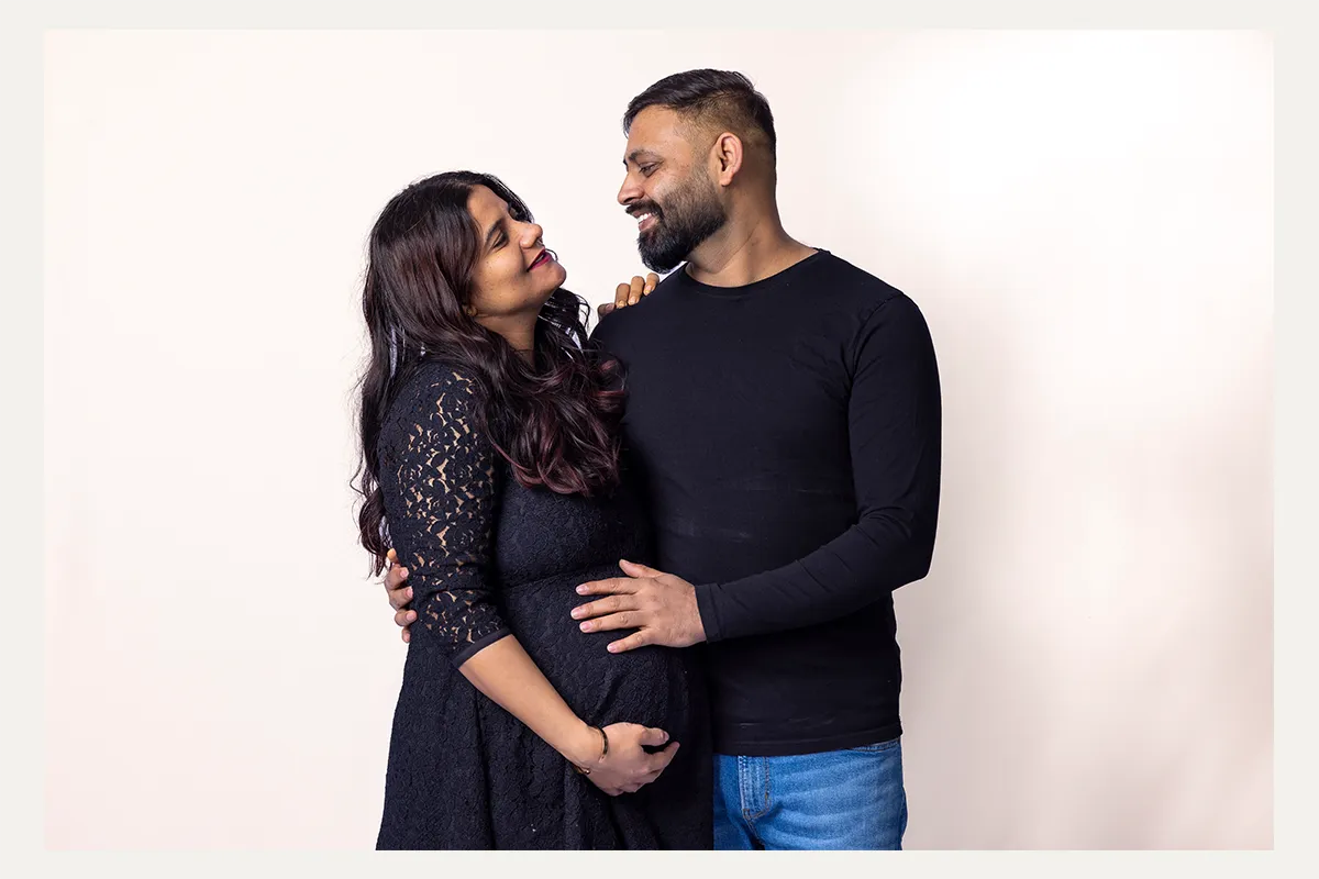 3 Expectant couple smiling together during a Winnipeg studio maternity session