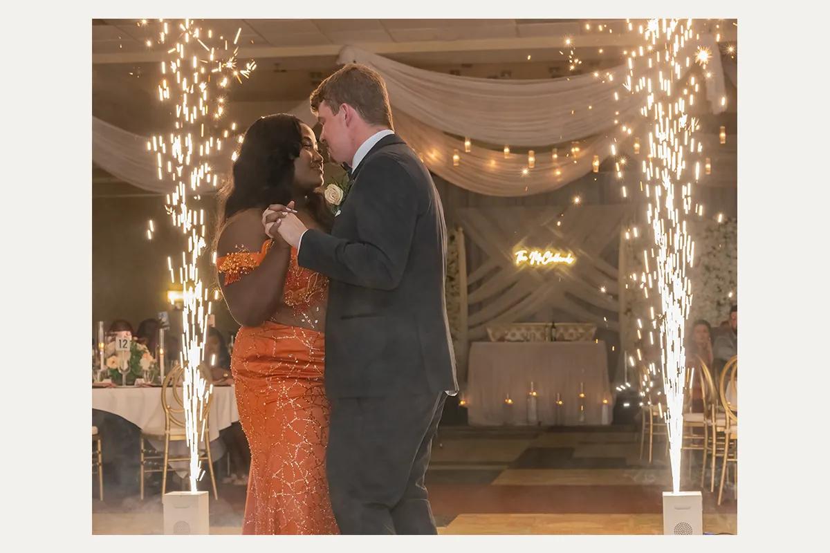 Couple sharing a first dance surrounded by sparkling light effects at their wedding reception