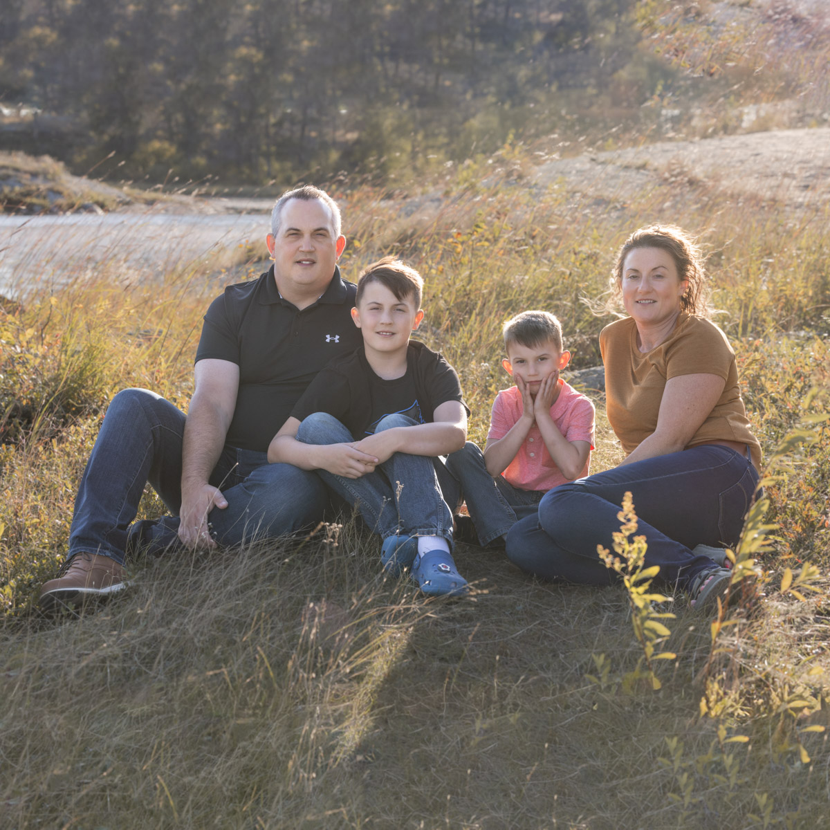 Family Sitting in the tall grass at Alf Hole Goose Sanctuary during their Fall Family Session
