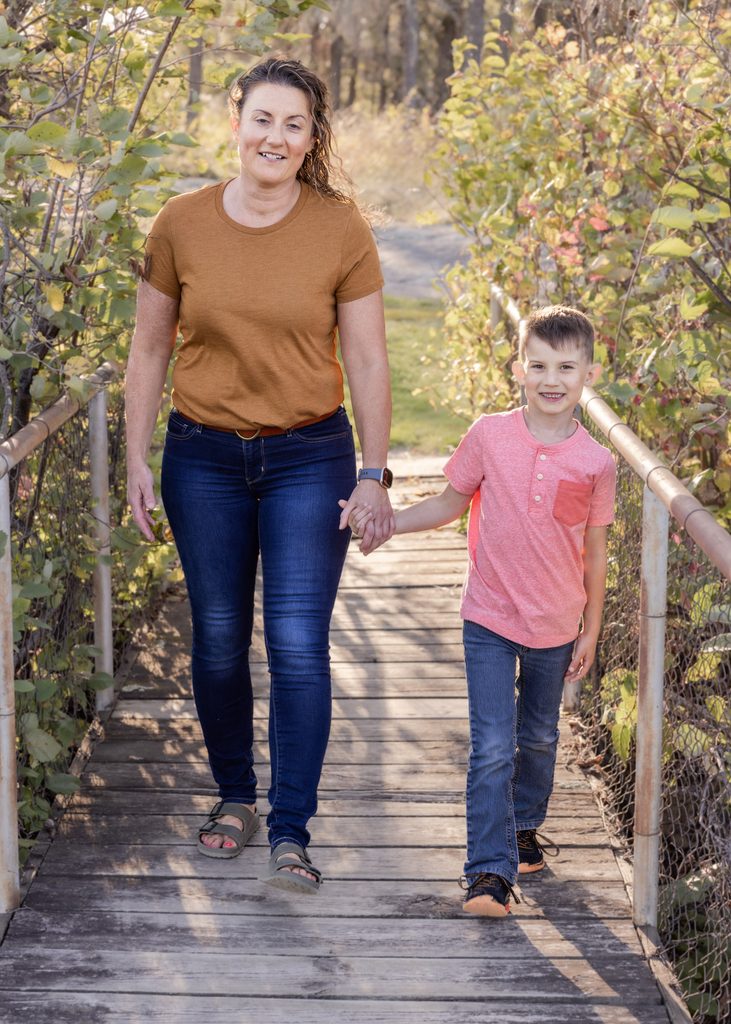 Mother and son walking together across a footbridge at Alf Hole Goose Sanctuary