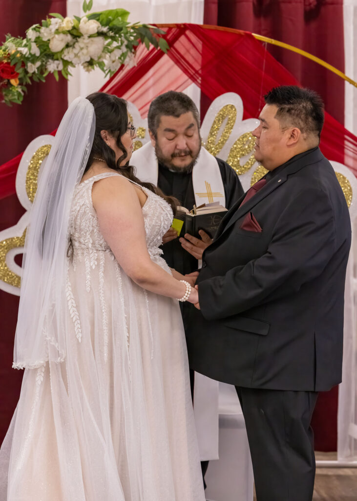Bride and groom exchanging vows during their Victoria Inn wedding ceremony
