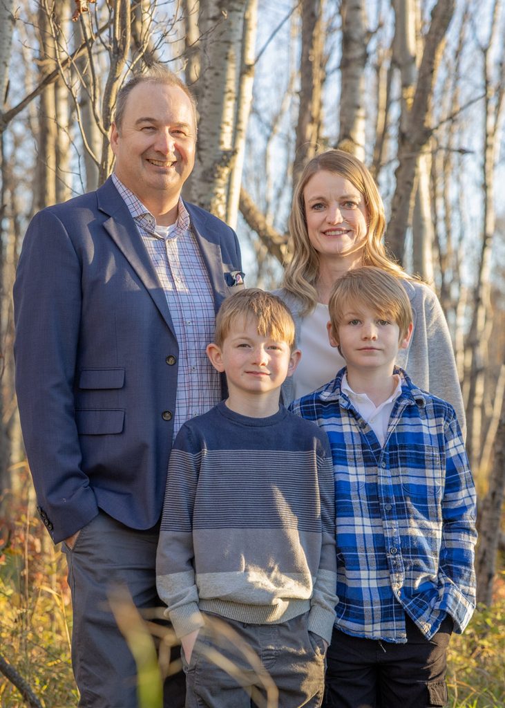 Family portrait among the autumn trees at Assiniboine Forest in Winnipeg