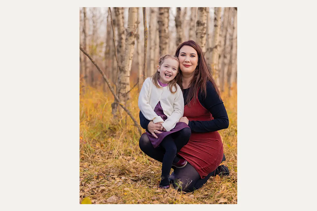 Mother and daughter laughing together during a fall family session