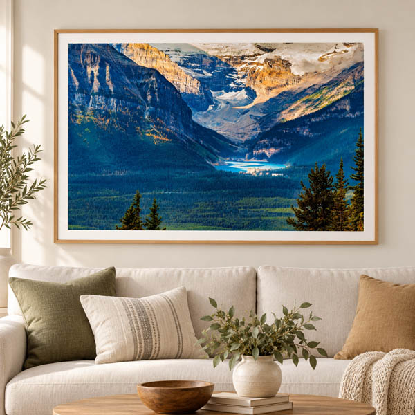 Framed Lake Louise landscape photograph displayed above a linen sofa