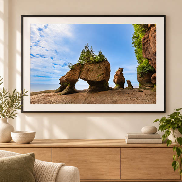 Framed Hopewell Rocks photograph displayed above an oak console
