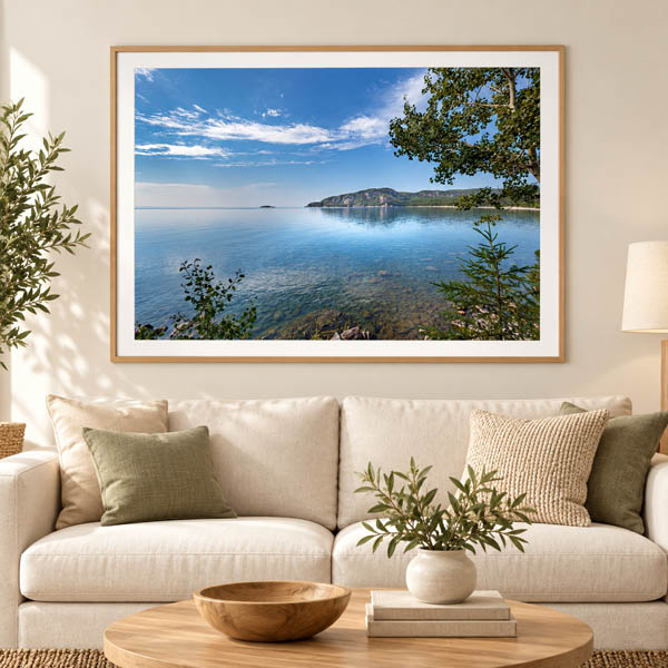 Framed Alona Bay landscape photograph displayed above a cream sofa
