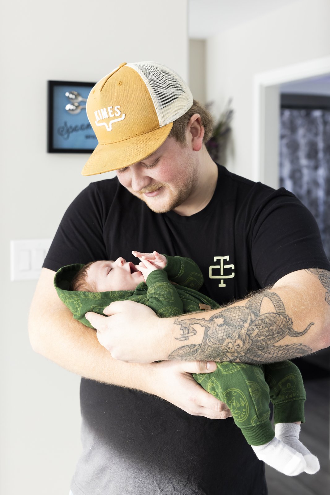 Father looking down at his newborn baby during an in-home session.