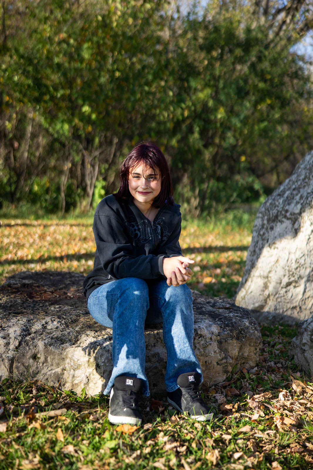 Older daughter sitting on a rock for an individual portrait.