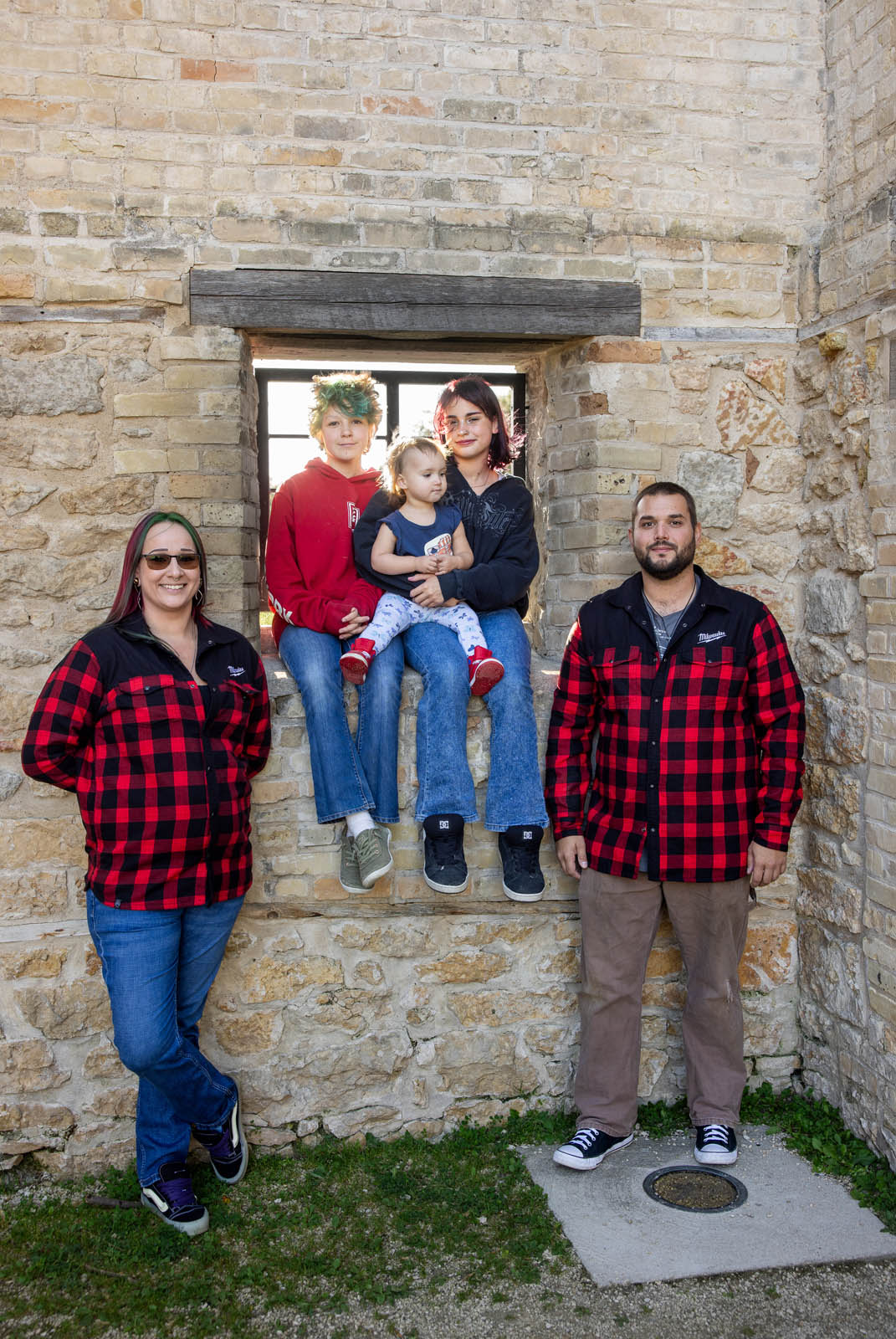 Family of five gathered around a stone window in the monastery ruins.