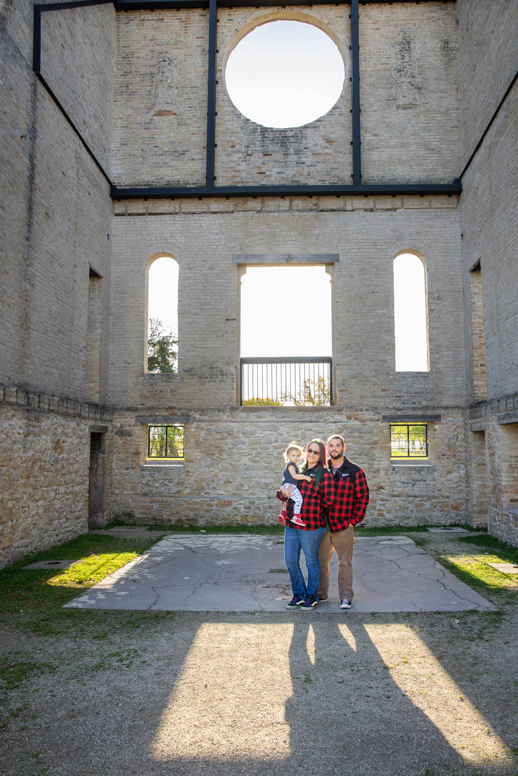 Parents and their youngest child standing inside the stone ruins at St. Norbert Monastery.