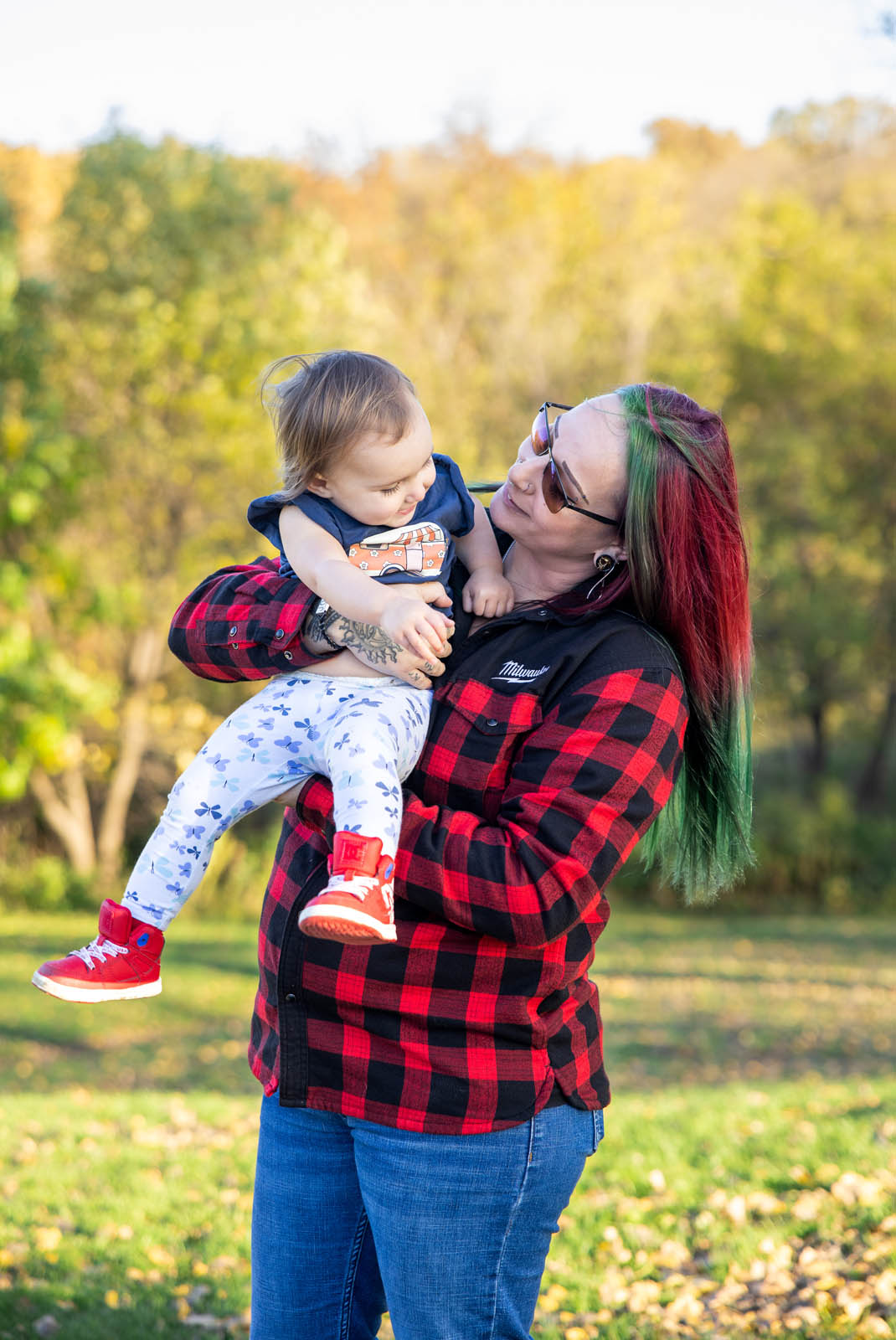 Mother holding her youngest child as they look at each other.