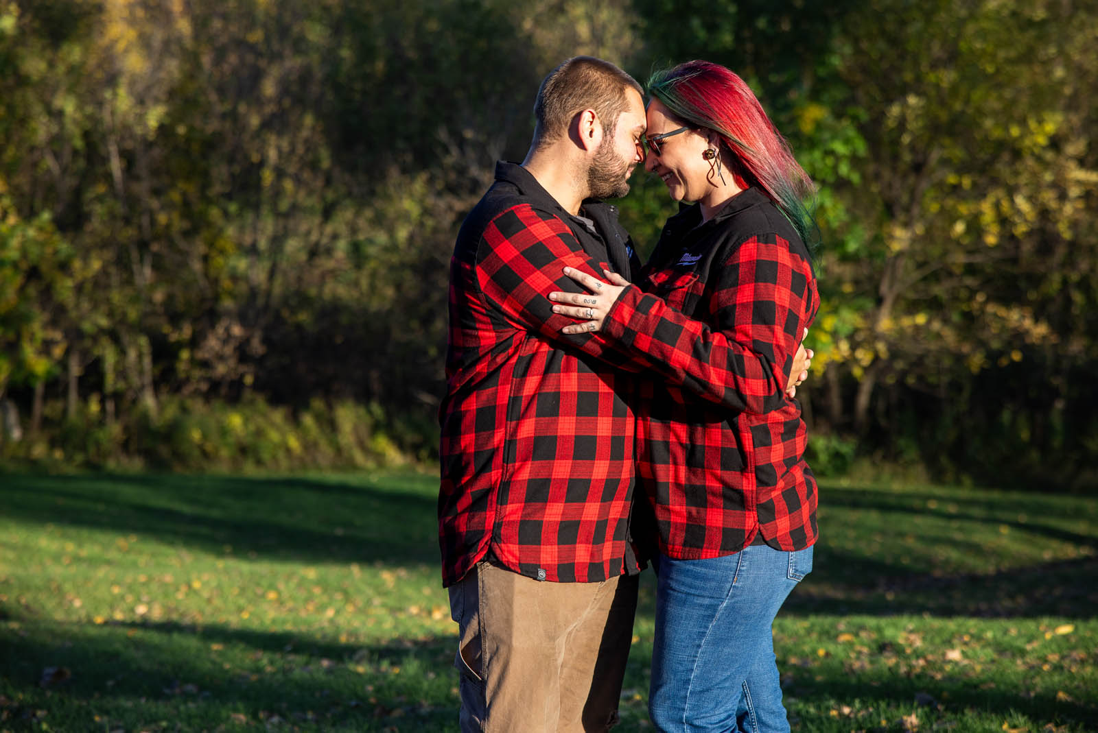 Parents smiling with their foreheads touching outdoors.