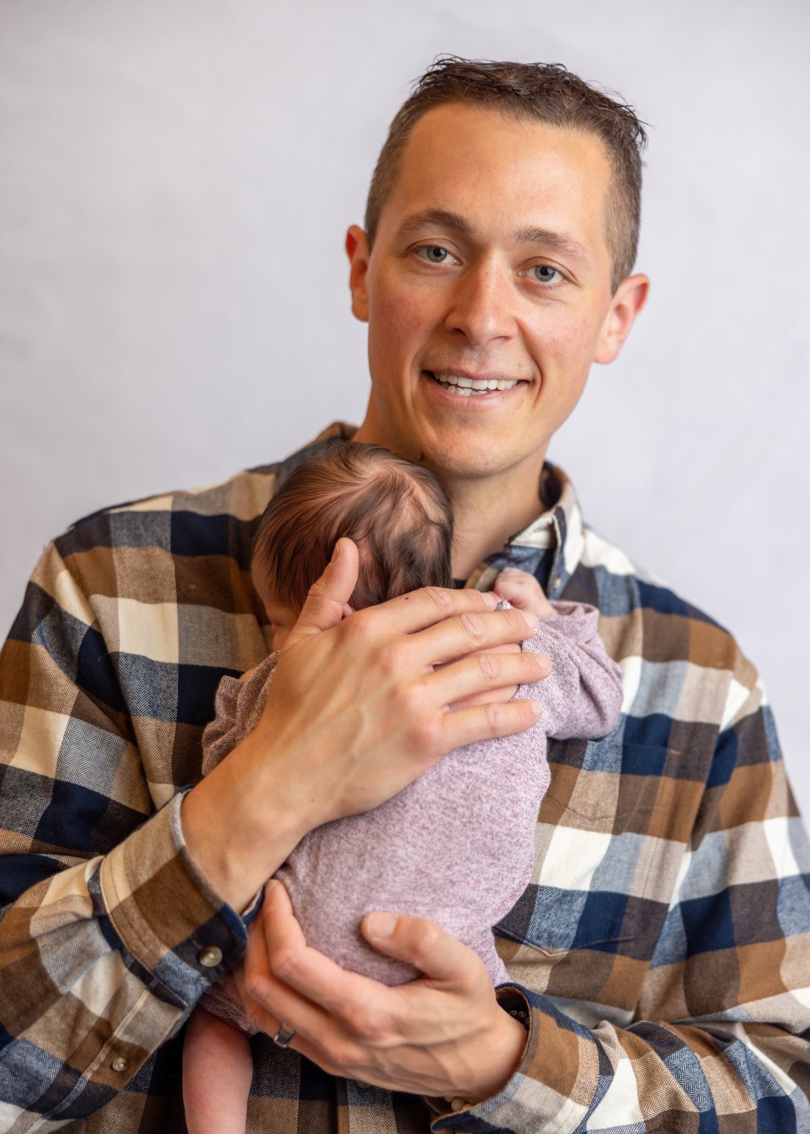 Father holding his newborn baby close to his chest.