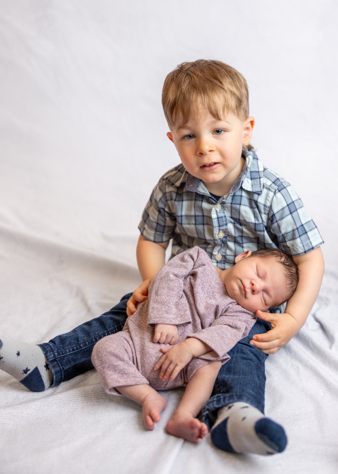 Older sibling seated with the newborn baby.