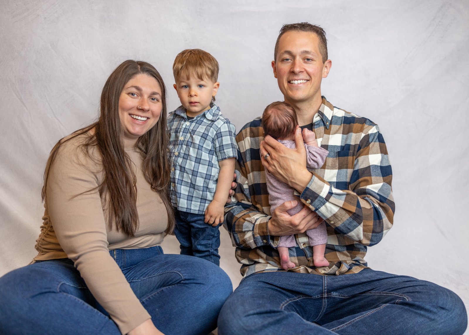 Parents and older sibling together with their newborn baby.